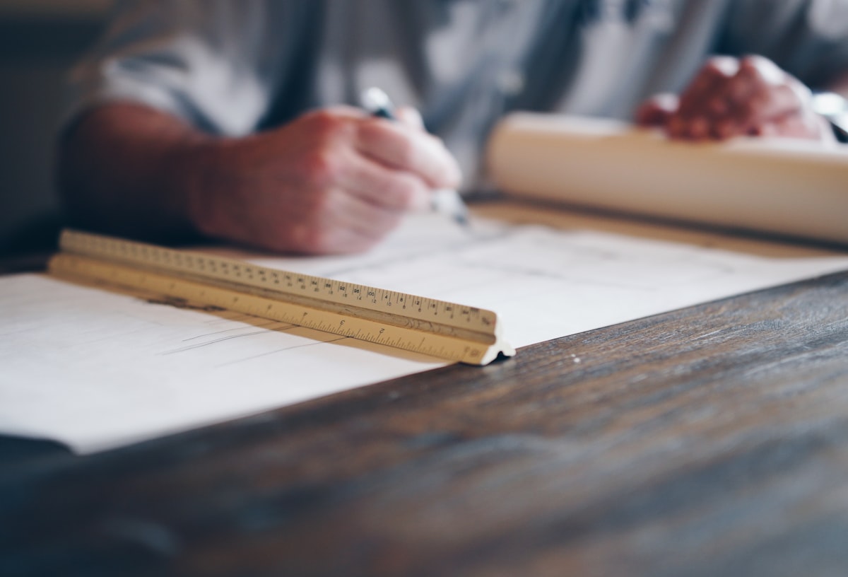 Professionista al lavoro su disegni tecnici e planimetrie